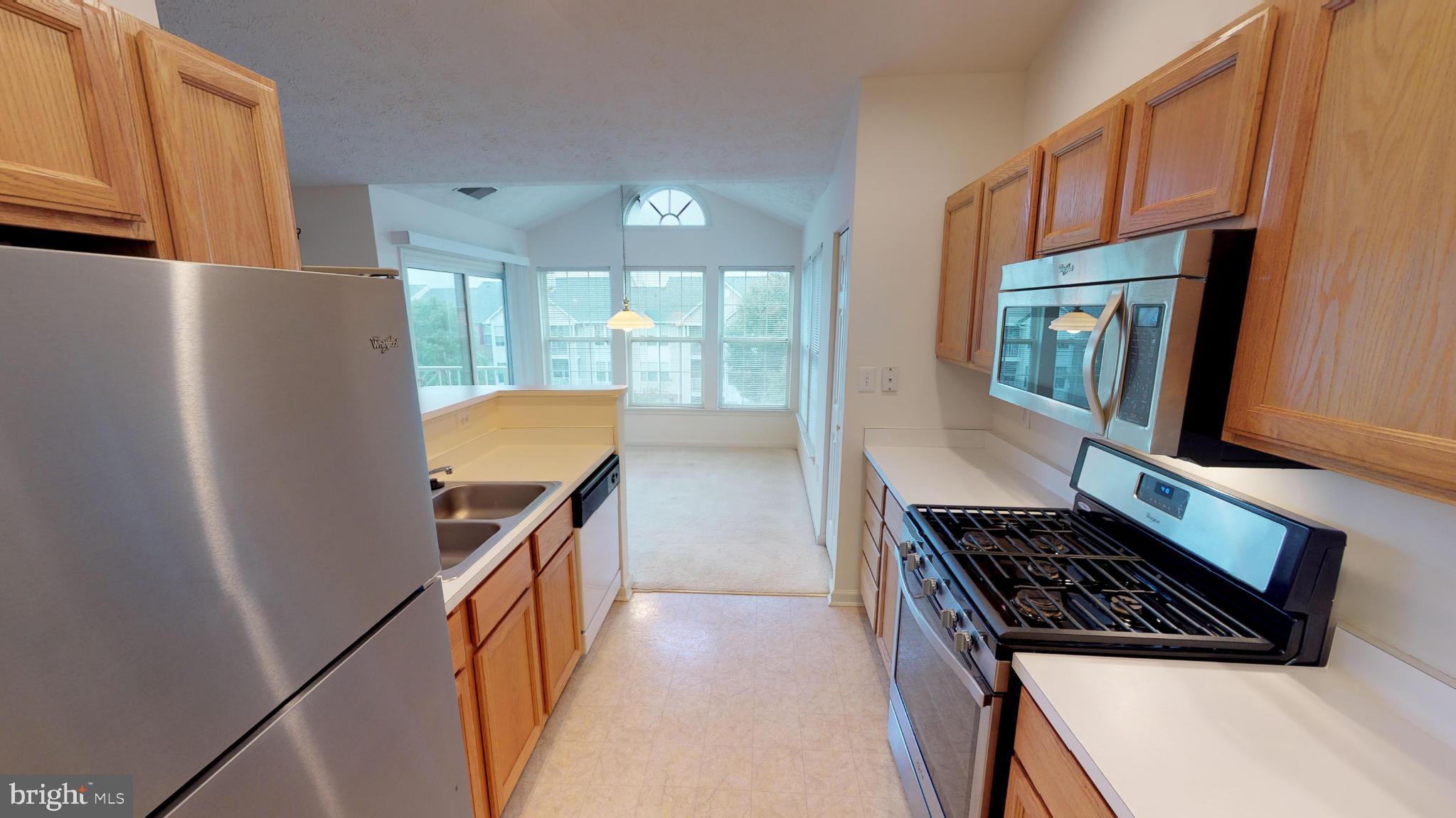 2443 Blue Spring Court, Unit 303 Odenton, MD 21113 - Photo 8 of 14 a kitchen with stainless steel appliances a stove a refrigerator and a microwave