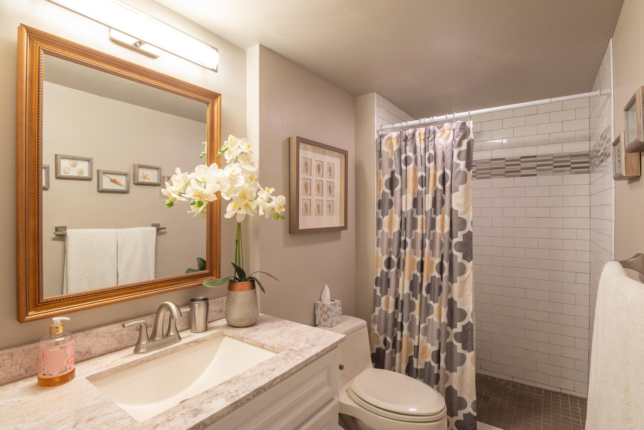 5403 Southeast Miles Grant Road, Unit 111 Stuart, FL 34997 - Photo 16 of 29 a bathroom with a granite countertop sink toilet and shower