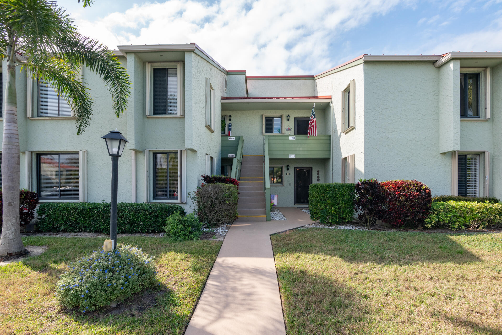 5403 Southeast Miles Grant Road, Unit 111 Stuart, FL 34997 - Photo 2 of 29 a front view of a house with a yard and garage