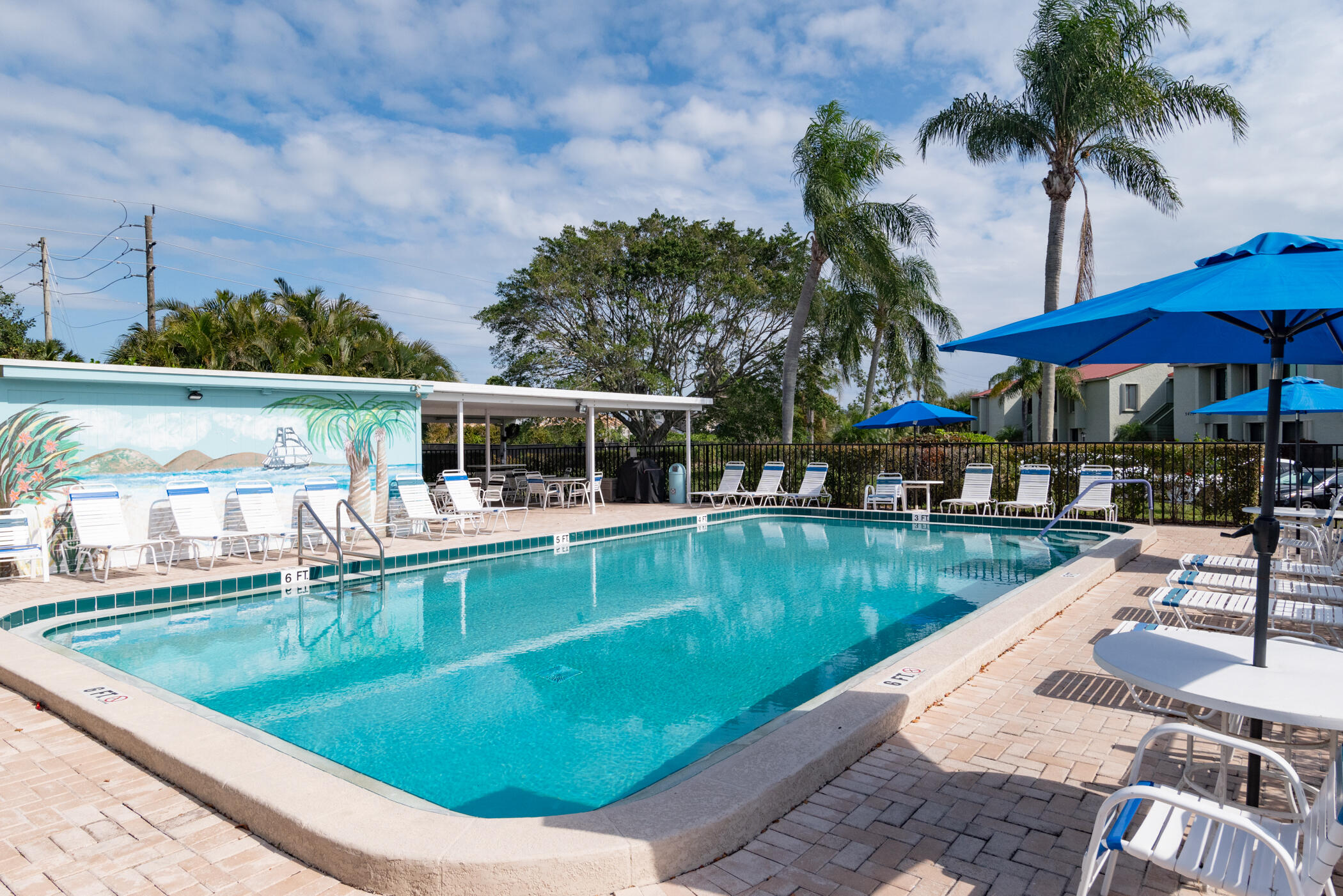 5403 Southeast Miles Grant Road, Unit 111 Stuart, FL 34997 - Photo 26 of 29 a view of a swimming pool with a patio and a yard