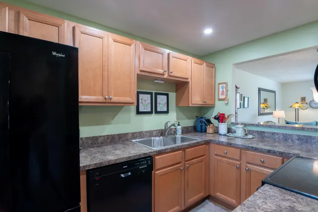 a kitchen with granite countertop wooden cabinets and a sink