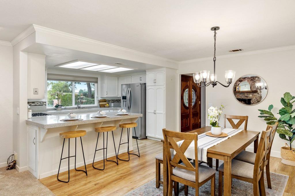 1317 Rincon Road Escondido, CA 92025 - Photo 13 of 42 a dining hall with stainless steel appliances kitchen island granite countertop a dining table chairs and a refrigerator