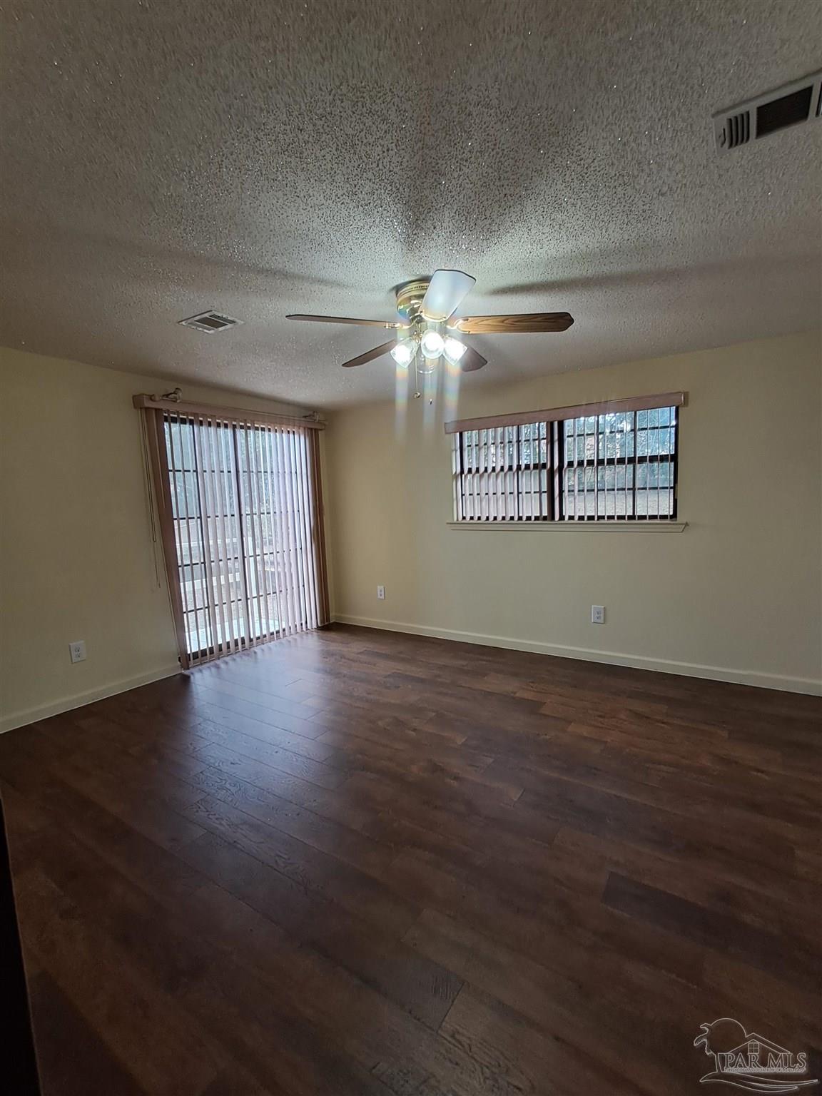 4929 Springhill Drive Pensacola, FL 32503 - Photo 15 of 16 an empty room with wooden floor and windows