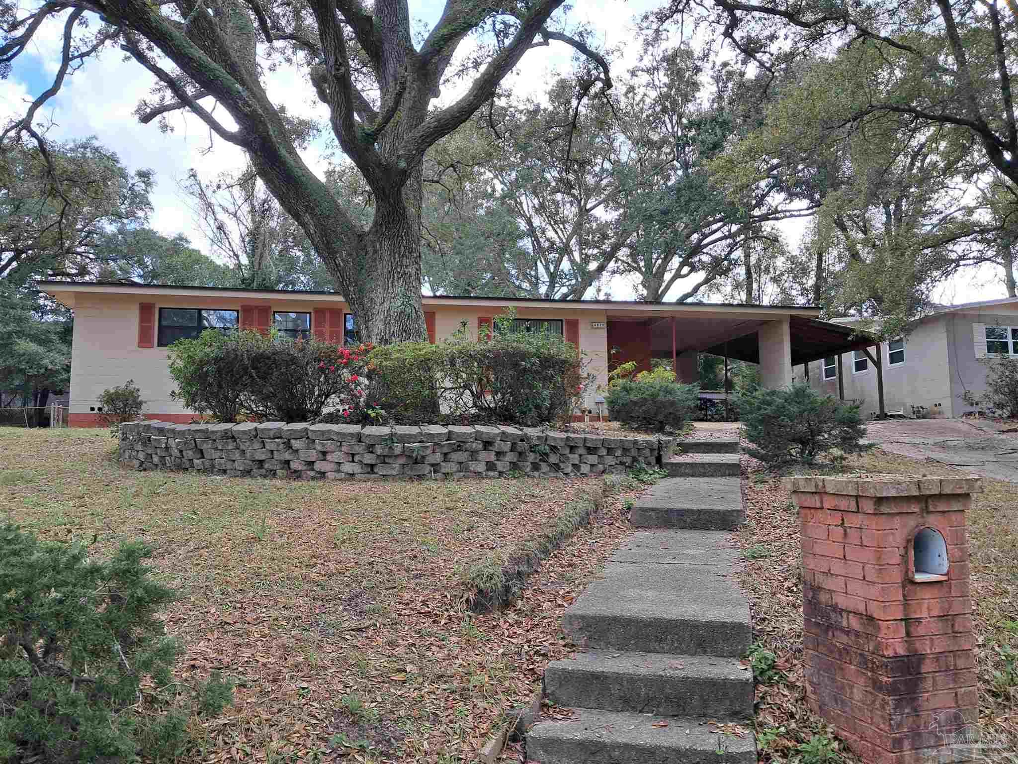 4929 Springhill Drive Pensacola, FL 32503 - Photo 2 of 16 a front view of a house with garden