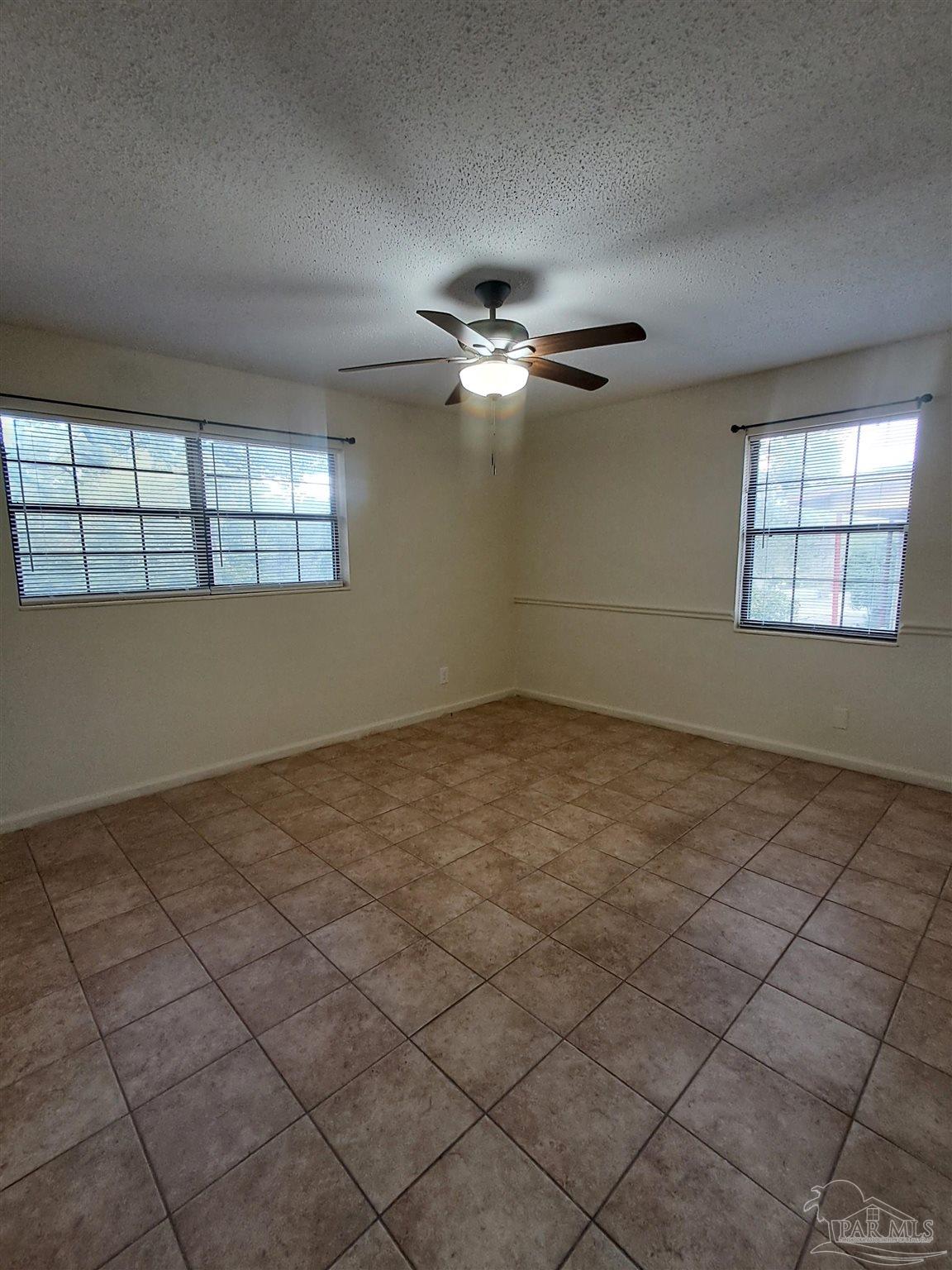 4929 Springhill Drive Pensacola, FL 32503 - Photo 7 of 16 an empty room with windows and ceiling fan