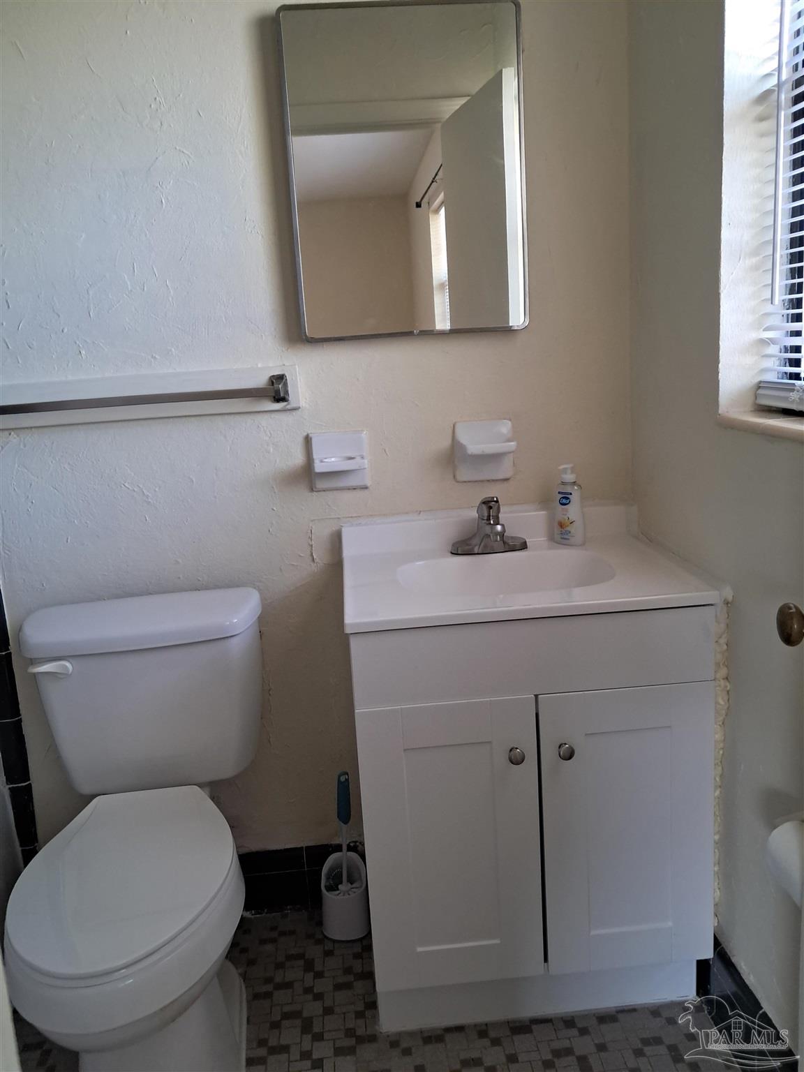 4929 Springhill Drive Pensacola, FL 32503 - Photo 9 of 16 a bathroom with a toilet sink and mirror