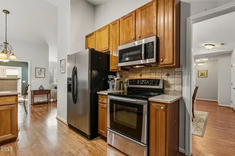 a kitchen with stainless steel appliances a stove a microwave and a hard wood floors