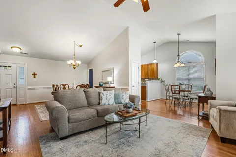 a living room with furniture kitchen view and a chandelier