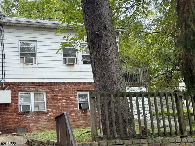a front view of a house with a tree