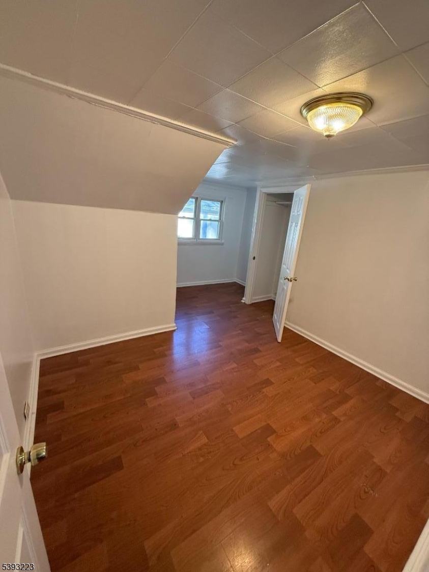 224 Westervelt Avenue Hawthorne, NJ 07506 - Photo 4 of 9 an empty room with wooden floor and windows