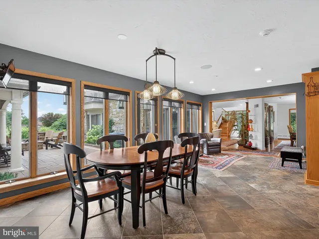 a living room with couches chairs and kitchen view with wooden floor
