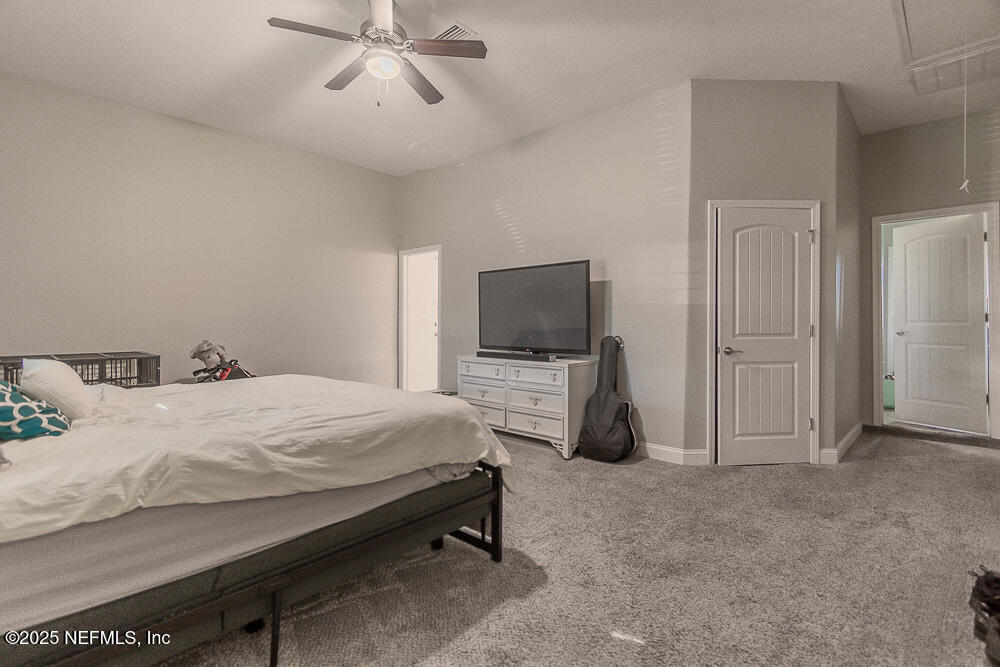 14443 Stacey Road Jacksonville, FL 32250 - Photo 15 of 31 a bedroom with a bed and a flat tv screen on the dresser