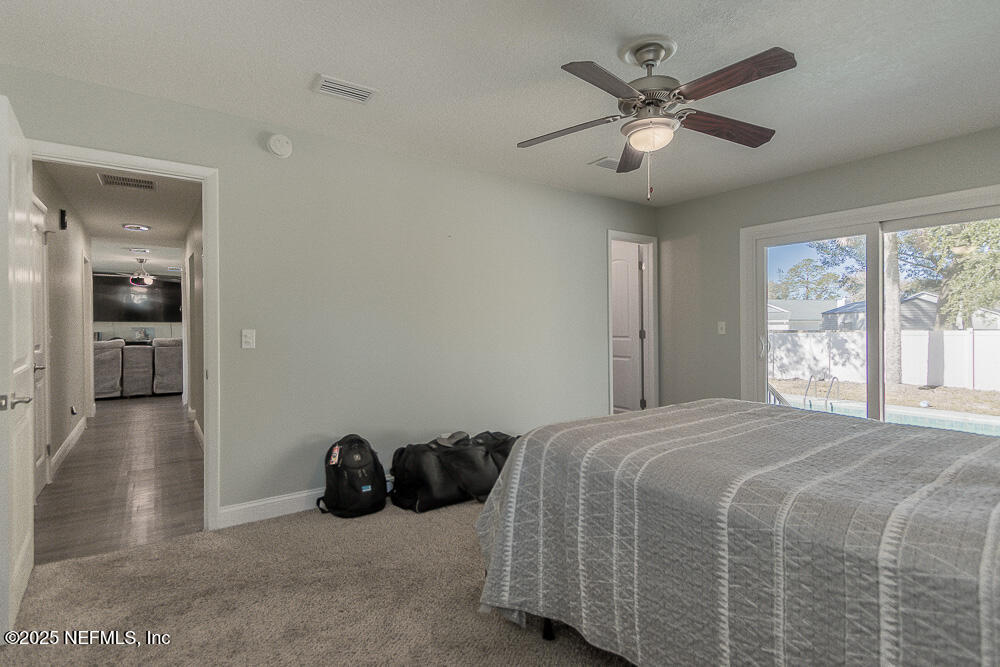 14443 Stacey Road Jacksonville, FL 32250 - Photo 19 of 31 a bedroom with a bed and a large window