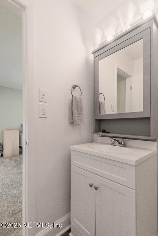 14443 Stacey Road Jacksonville, FL 32250 - Photo 21 of 31 a bathroom with a sink and a mirror