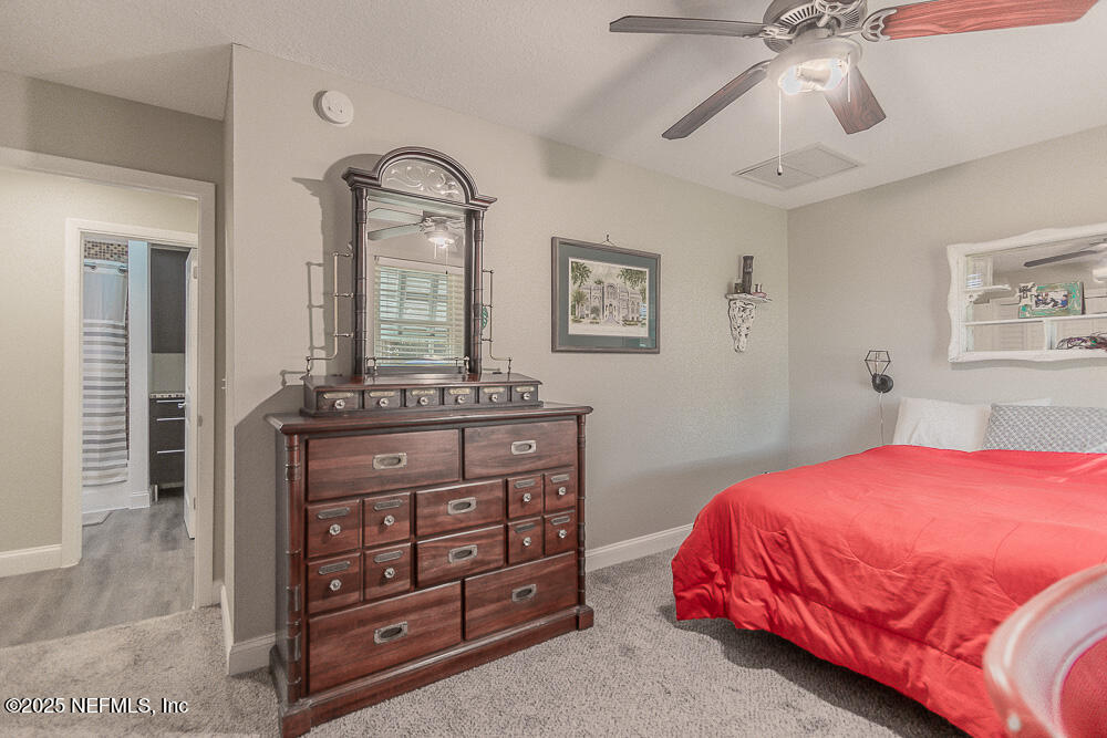 14443 Stacey Road Jacksonville, FL 32250 - Photo 22 of 31 a bedroom with a bed and a dresser