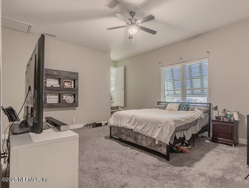 14443 Stacey Road Jacksonville, FL 32250 - Photo 5 of 31 a bedroom with a bed a couch and a window