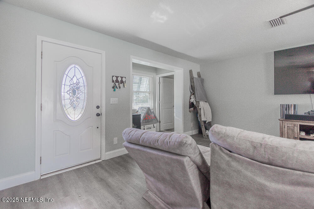 14443 Stacey Road Jacksonville, FL 32250 - Photo 10 of 31 a living room with furniture a flat screen tv and a wall clock