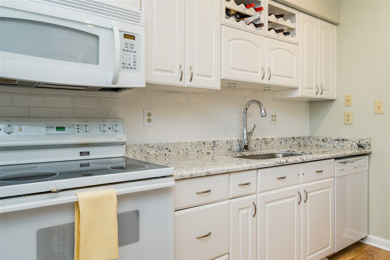 7010 Sandy Forks Road, Unit 207 Raleigh, NC 27609 - Photo 14 of 27 Gorgeous new granite and subway tile backsplash match perfectly with the white cabinets. Kitchen