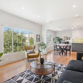 a living room with furniture potted plant and a large window
