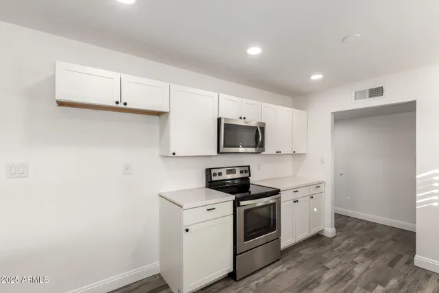 a kitchen with stainless steel appliances white cabinets and sink
