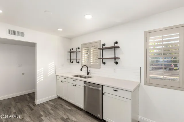 a kitchen with a sink cabinets and wooden floor