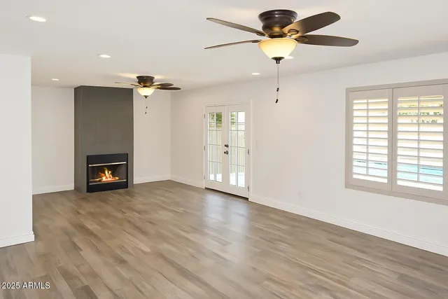 a view of an empty room with a window and a fireplace