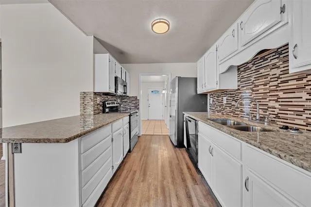 a kitchen with stainless steel appliances granite countertop a stove and a sink