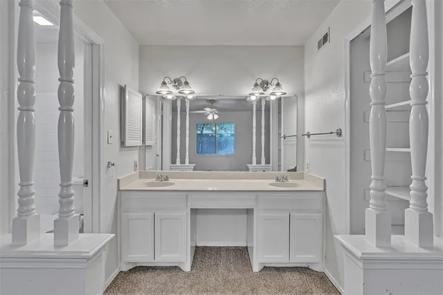 a bathroom with a double vanity sink mirror and bathtub