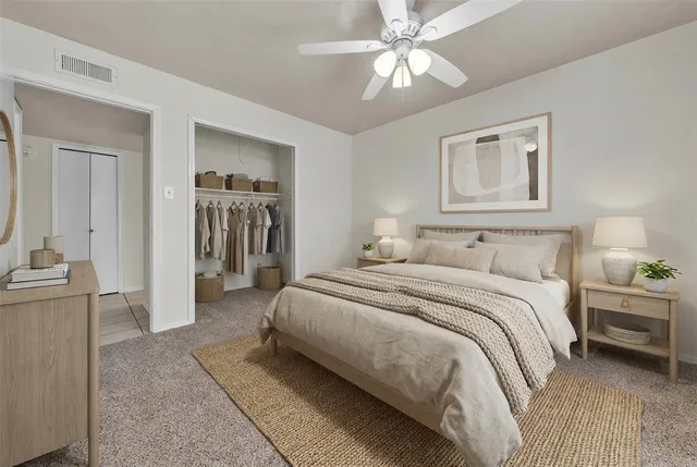 a spacious bedroom with a bed and a chandelier