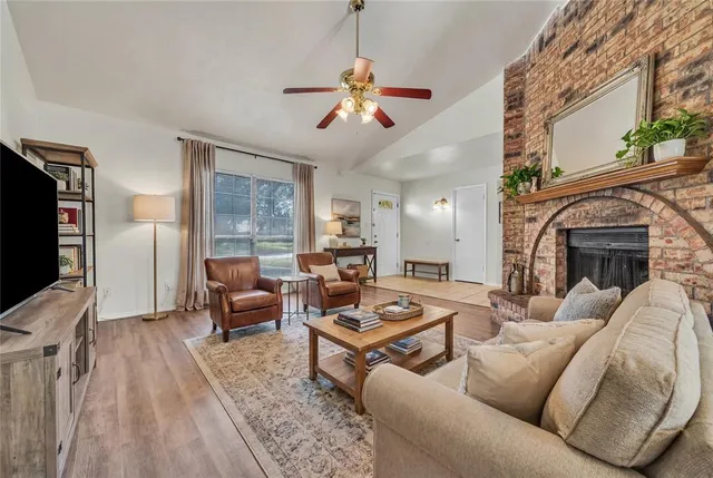 a living room with furniture a fireplace and a flat screen tv