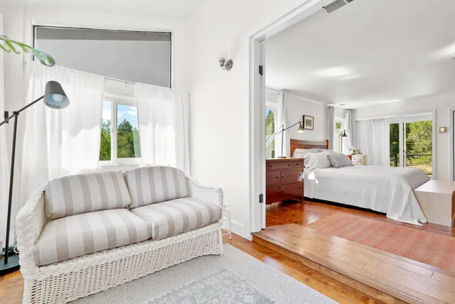 a backyard of a house with large trees and outdoor seating