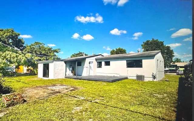 a view of a house with a yard and potted plants