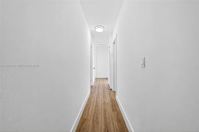 a view of a hallway with wooden floor