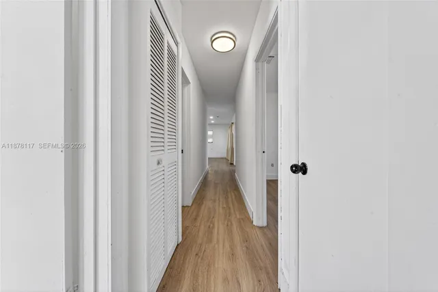 a view of a hallway with wooden floor