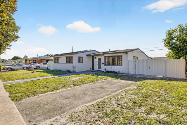 a view of a house with backyard and sitting area