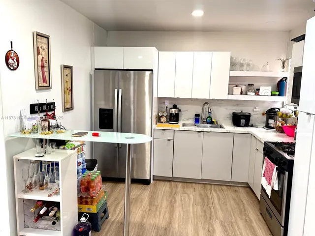 a kitchen with stainless steel appliances a stove refrigerator sink and cabinets