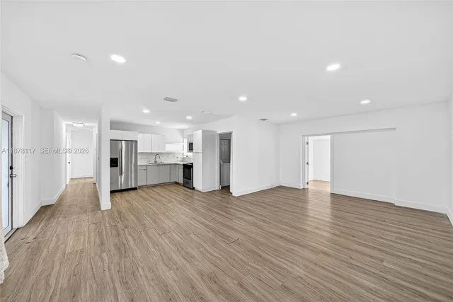 a view of an empty room with wooden floor