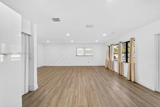 a view of a room with wooden floor and a window