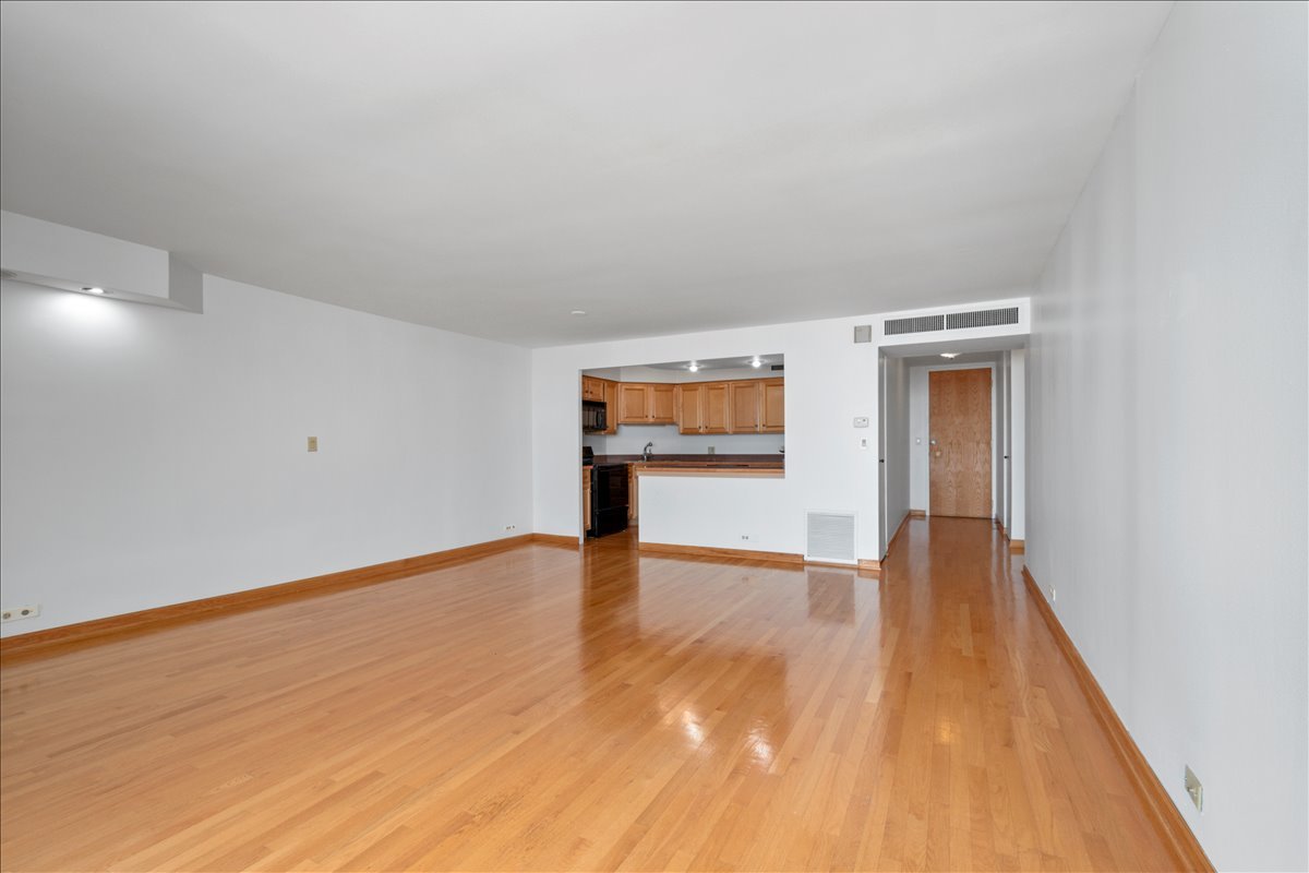 6033 North Sheridan Road, Unit 34M Chicago, IL 60660 - Photo 7 of 48 a view of an empty room with wooden floor and a window