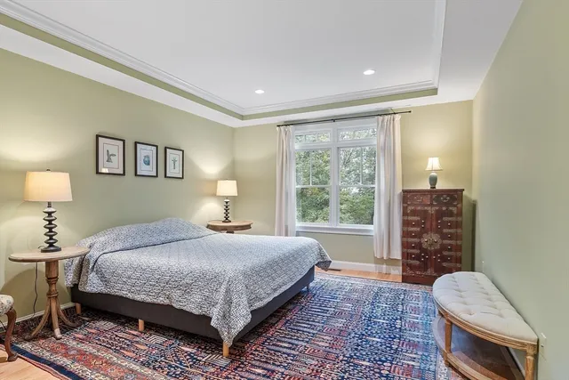 a bedroom with a bed a lamp and a large window