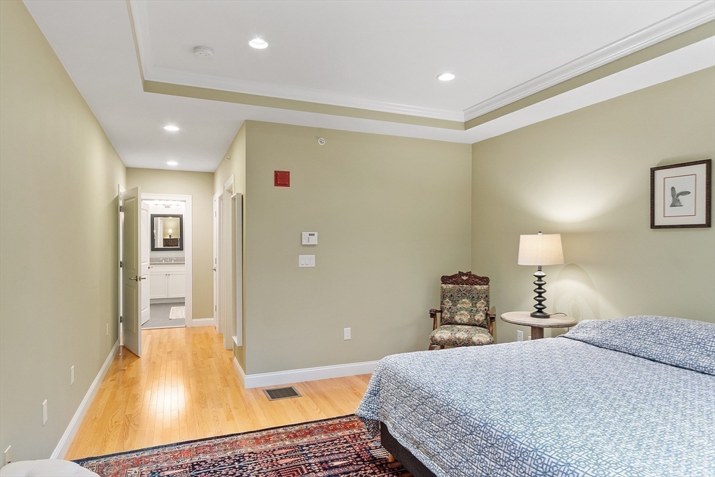 51 South Cottage Road, Unit 112 Belmont, MA 02478 - Photo 14 of 41 a bedroom with a bed and wooden floor