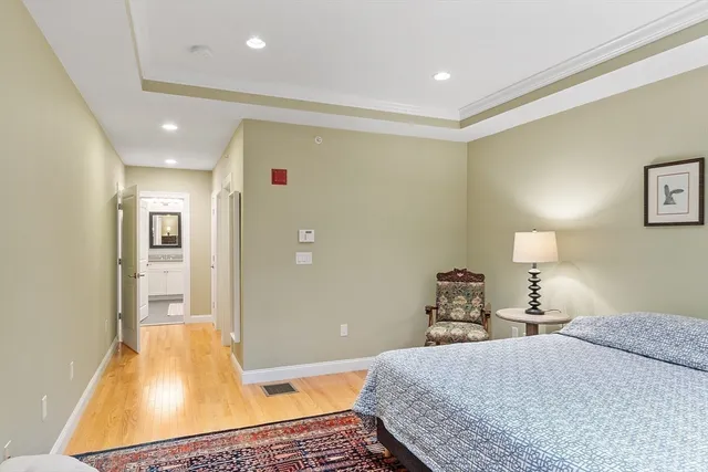 a bedroom with a bed and wooden floor