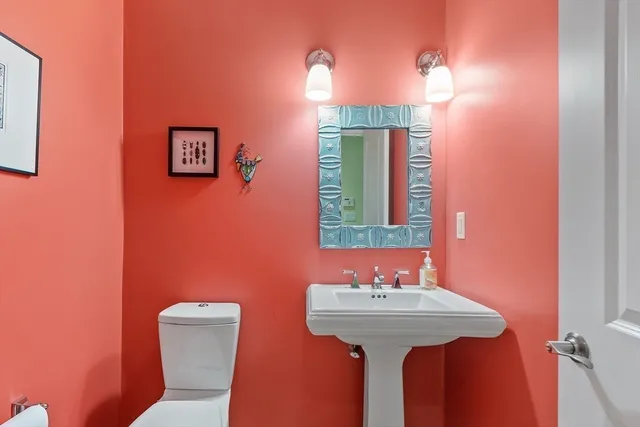 a bathroom with a sink mirror and toilet