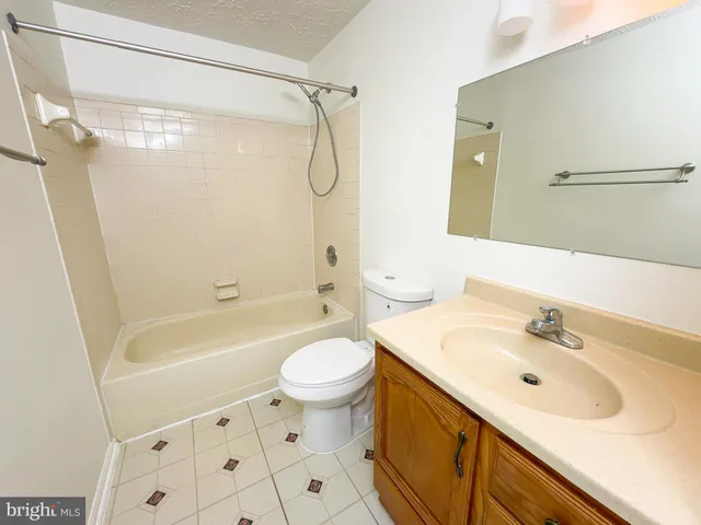 a bathroom with a sink a mirror toilet and bathtub