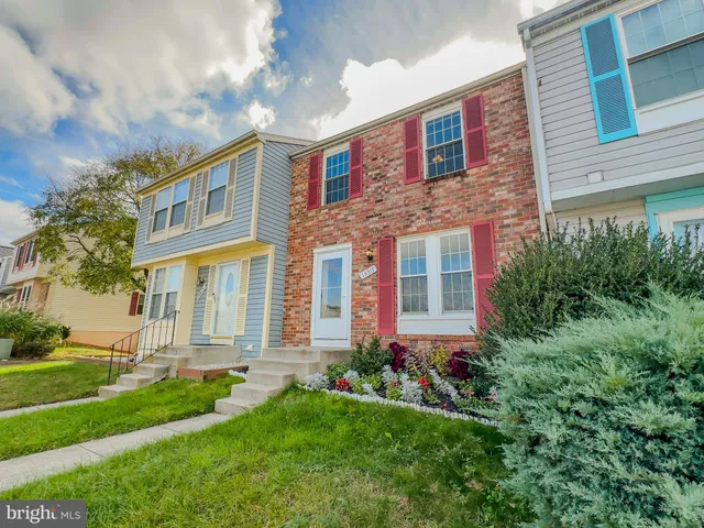 a front view of a house with a yard and trees