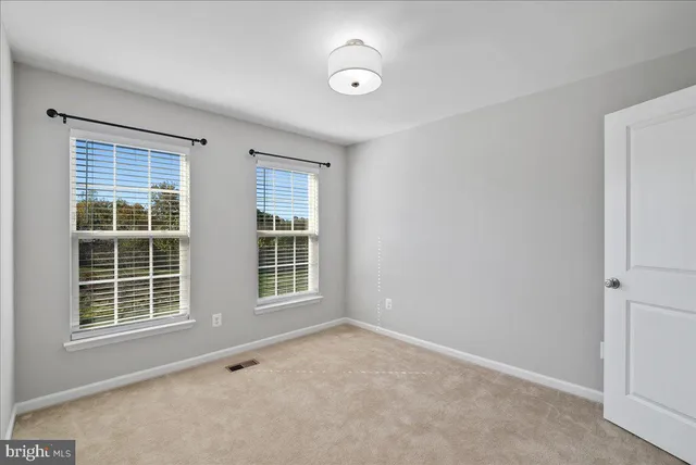 an empty room with closet and entryway