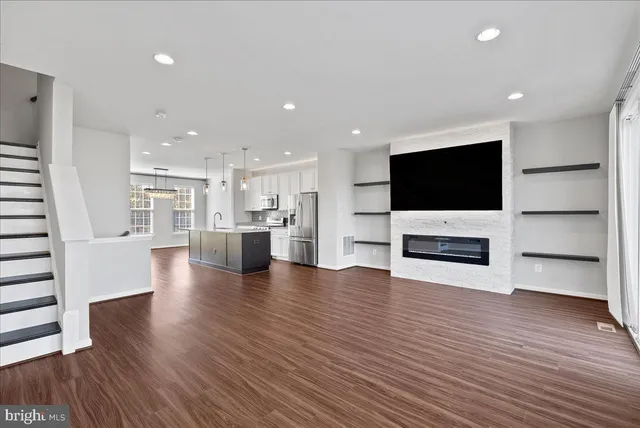 a view of a living room with kitchen and flat screen tv