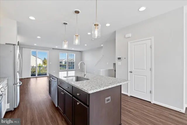 a kitchen with a sink chandelier and wooden floor