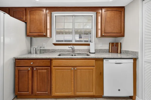 a kitchen with granite countertop cabinets sink and window