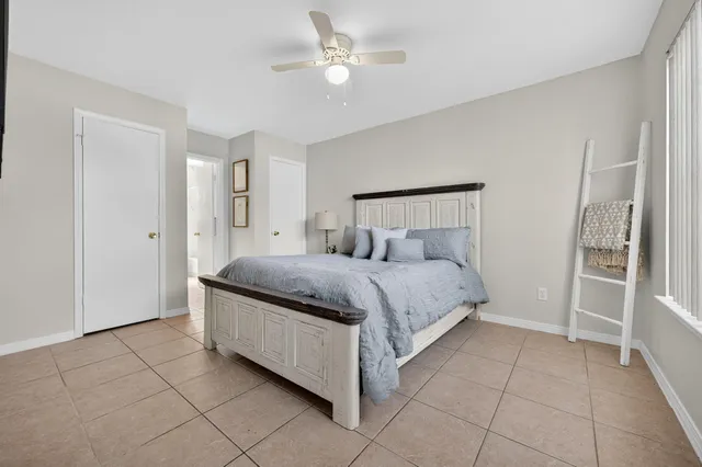 a spacious bedroom with a bed and a lamp